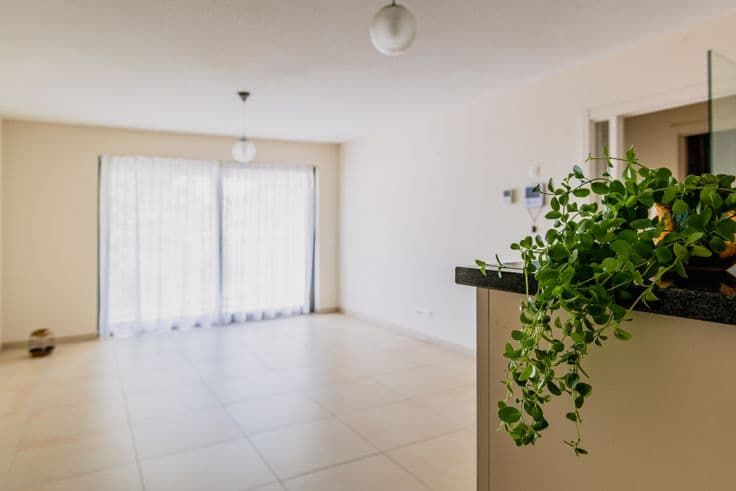 Lichte woonkamer van de assistentiewoning met een groot schuifraam naar het terras